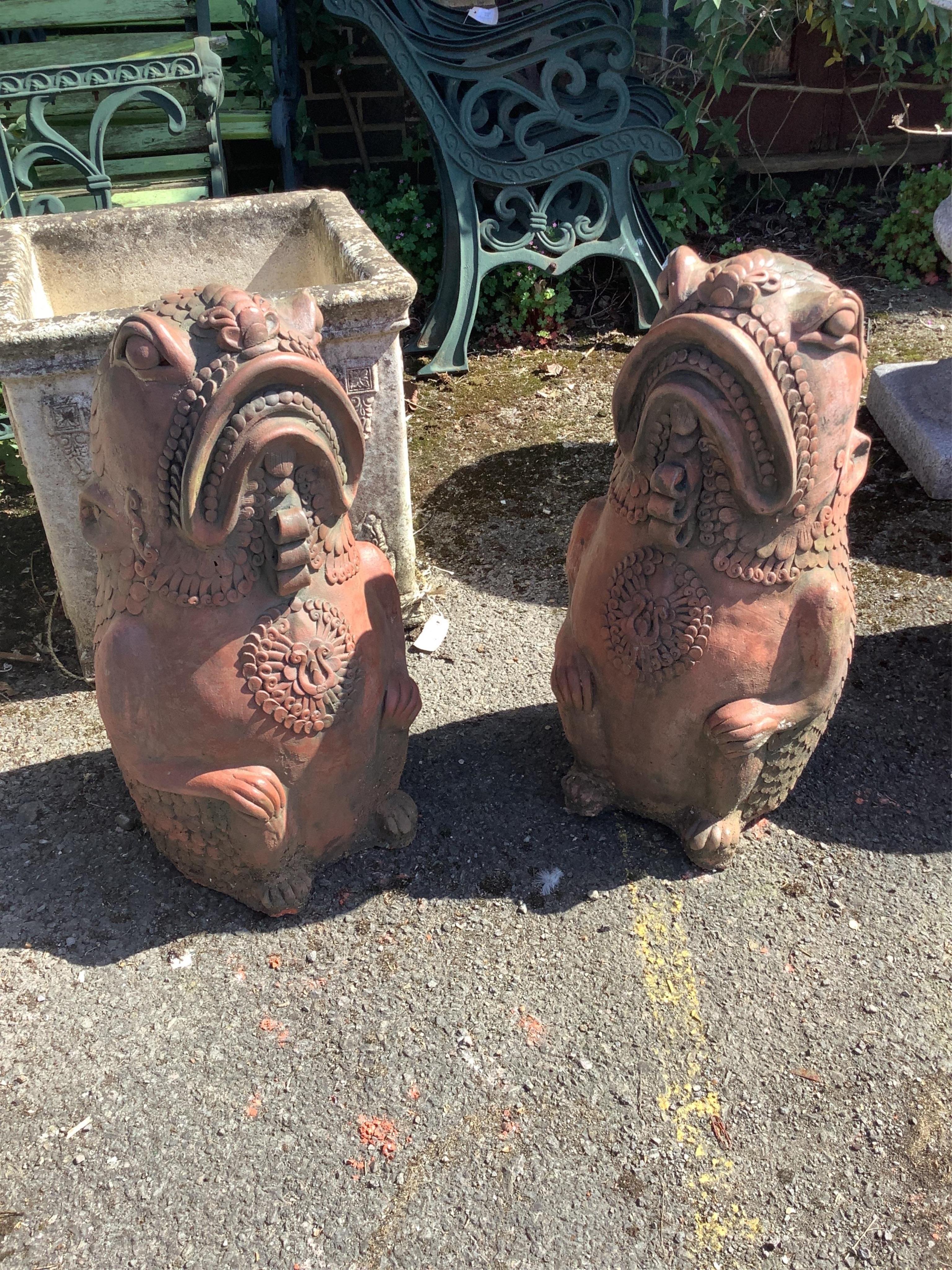 A pair of cast terracotta Oriental fish garden ornaments, height 61cm